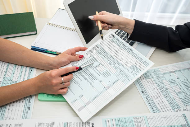 istock two hand filling us tax form, 1040 1359521071