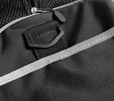 Zipper and buckle detail on a retroreflective sports bag