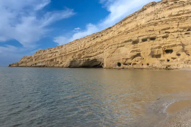 Photo of Stunning neolithic era caves on the cliff of Matala beach, Southern Crete, Greece. Used as historically used as living spaces and tombs
