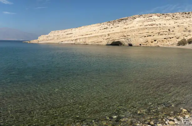 Photo of Stunning neolithic era caves on the cliff of Matala beach, Southern Crete, Greece. Used as historically used as living spaces and tombs