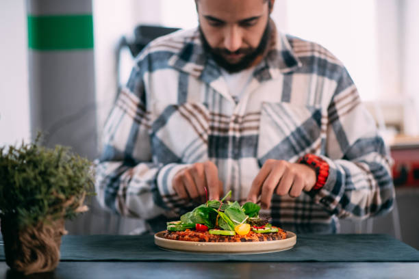 istock Man Eats Vegetarian Pizza With Wooden Cutlery 1359524468