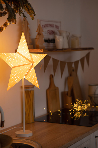 Christmas decoration and glowing lamp in the shape of star on the kitchen. Christmas concept.