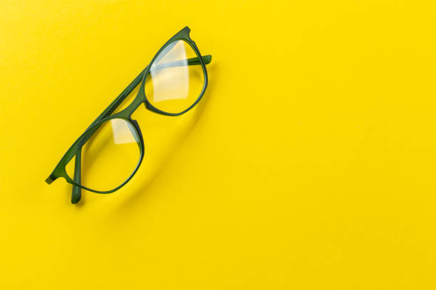 istock Stylish eyeglasses over yellow background. Optical store, glasses selection, eye test, vision examination at optician, fashion accessories concept. 1359525370