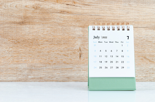 The July 2022 desk calendar on white table.