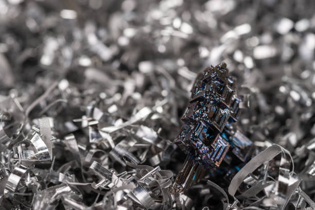 Perfect colorful bismuth crystals on the metal shavings from miling machine. Close-up view, side view.\nColorful bismuth crystals on the silver background. Great for wallpaper.