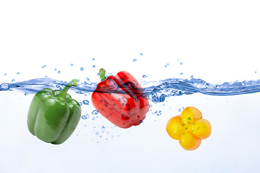 Bell pepper (green, yellow and red bellpepper) in water splash isolated on white background. Copy space.