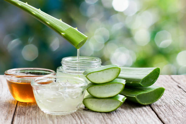 Aloe vera gel honey Aloe vera leaf with aloevera gel and honey on wooden table with green bokeh nature background. aloe juice stock pictures, royalty-free photos & images