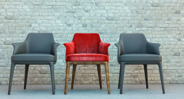 istock red armchairs with Modern 2 dark armchairs isolated on wall bricks background, Leadership concept, 1359534477