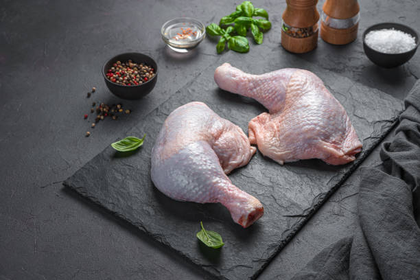 istock Two fresh chicken thighs and spices on a dark background. Cooking 1359535374