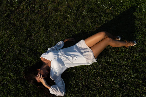 Young woman lying on grass stock photo