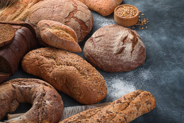 istock Assortment of rye and wheat bread on a dark background with flour 1359538782