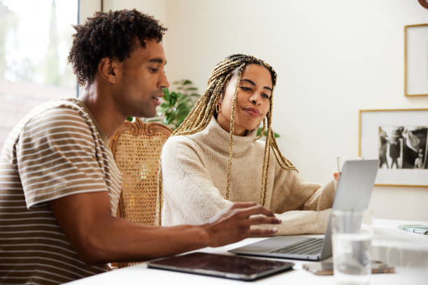 Some young couple working on a laptop together at home