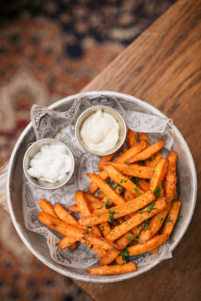 View from above of a plate with seasoned French fries and a dipping souse View from above of a plate with nicely decorated and seasoned French fries and a dipping souse next to it sweet potato french fries stock pictures, royalty-free photos & images