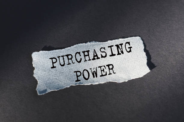 istock PURCHASING POWER. Text on torn paper on dark desk in sunlight. 1359539896