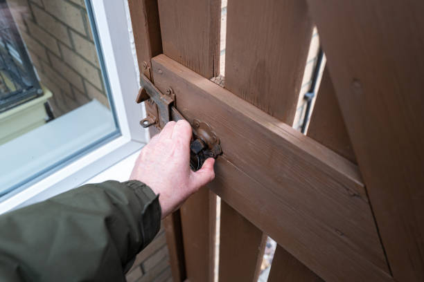 istock Homeowner unlatching an interior wooden side gate. 1359541248