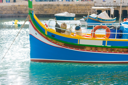Typical colorful painted fishing boats in Malta are anchored