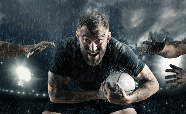 Rugby football player in action on dark arena background