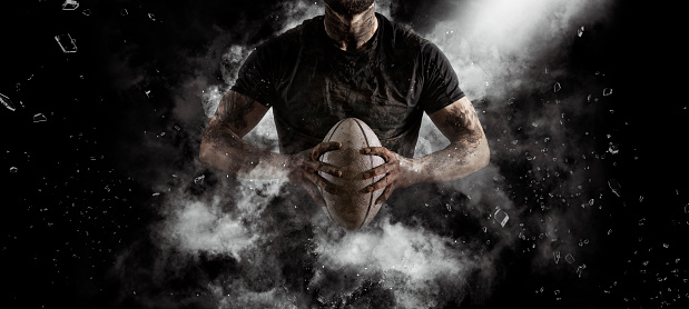 Rugby player in action on dark arena background