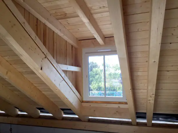 Timber frame construction of a roof truss with dormer window in the attic floor of a new residential building, construction work before the interior construction of an apartment