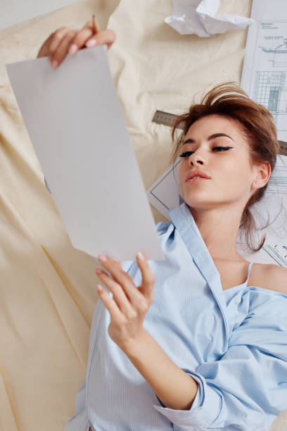 istock beautiful woman working with blueprints at home 1359545763