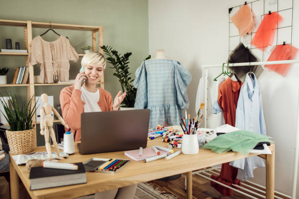 istock Young clothing designer having a business call at her studio 1359546861