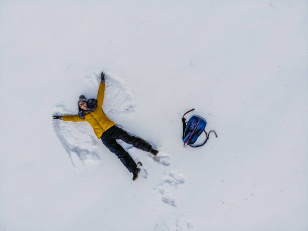 istock Young Woman Making A Snow Angel 1359547661