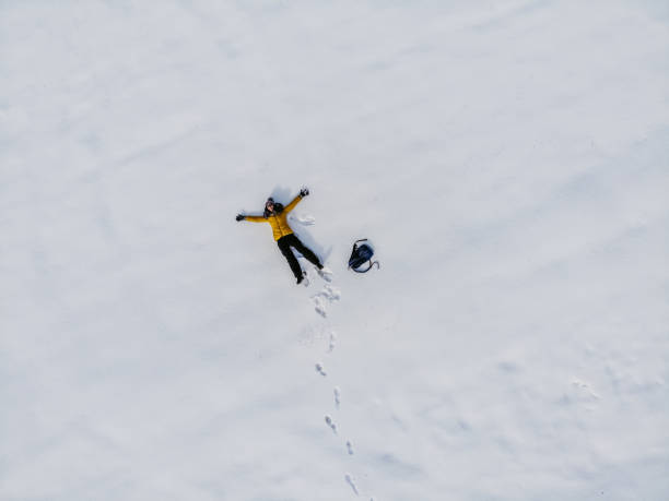 istock Young Woman Making A Snow Angel 1359547665