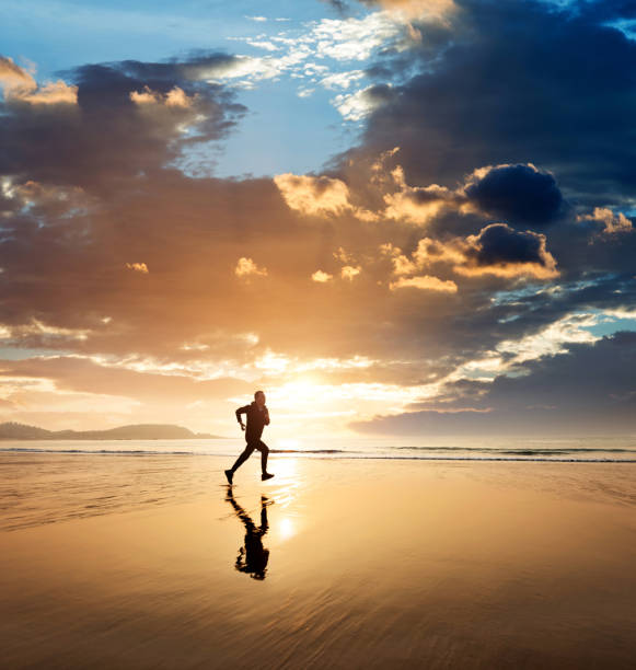 istock Man running on the golden beach 1359549735