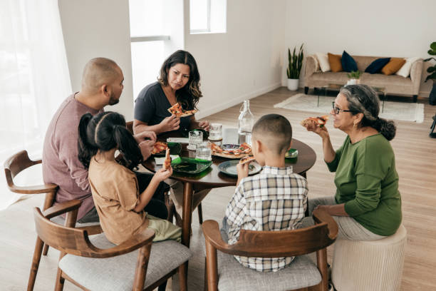 istock Multi-ethnic family having pizza for lunch 1359550090