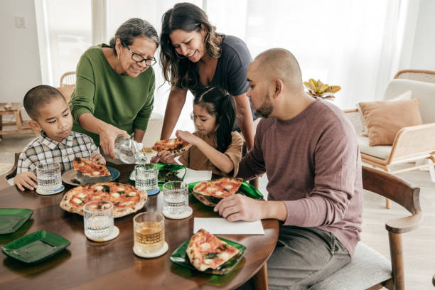Multi-ethnic family having pizza for lunch stock photo
