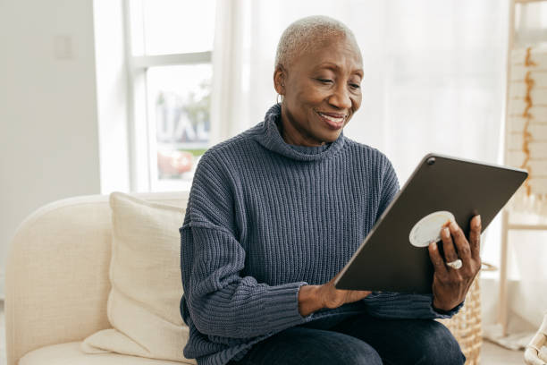 How to enjoy a free and clear retirement Senior women using tablet for online banking at home DisruptAgingCollection stock pictures, royalty-free photos & images