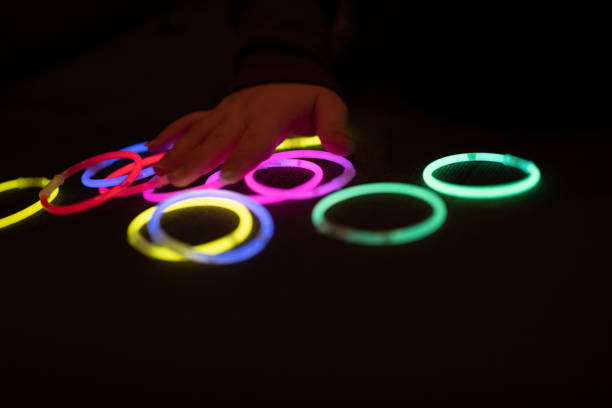 kolorowe pierścienie led świecące na czarnym tle. pierścienie świetlne w kolorze zielonym, różowym, czerwonym, żółtym, niebieskim. akcesoria imprezowe. bangles - dance and electronic blue shiny empty zdjęcia i obrazy z banku zdjęć