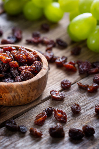 istock Raisins and grapes - wooden bowl 1359551701