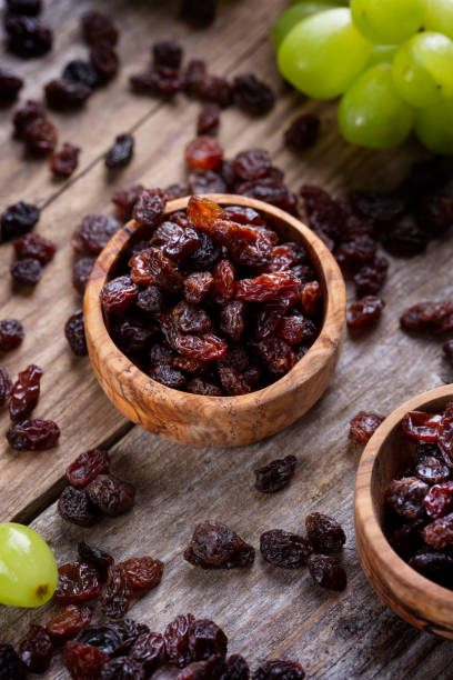 istock Raisins and grapes - wooden bowl 1359551744