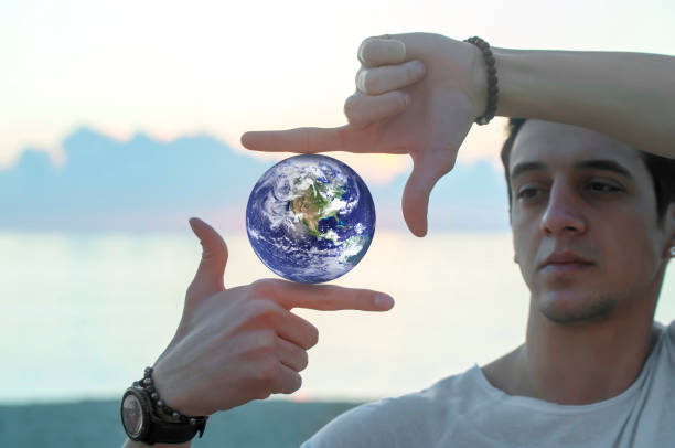 istock Planet in composition finger frame-imitation of capturing rays of sunlight on sunset 1359551753