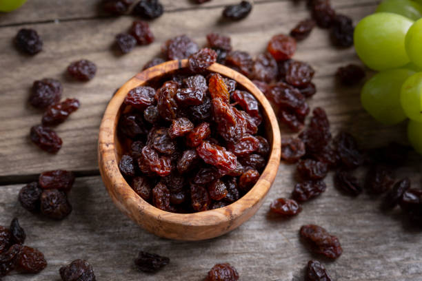 istock Raisins and grapes - wooden bowl 1359551755