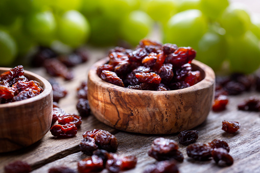 Raisins and grapes - wooden bowl