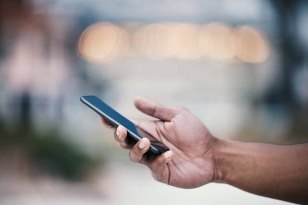istock Cropped shot of an unrecognizable man using his cellphone while standing outside 1359553840
