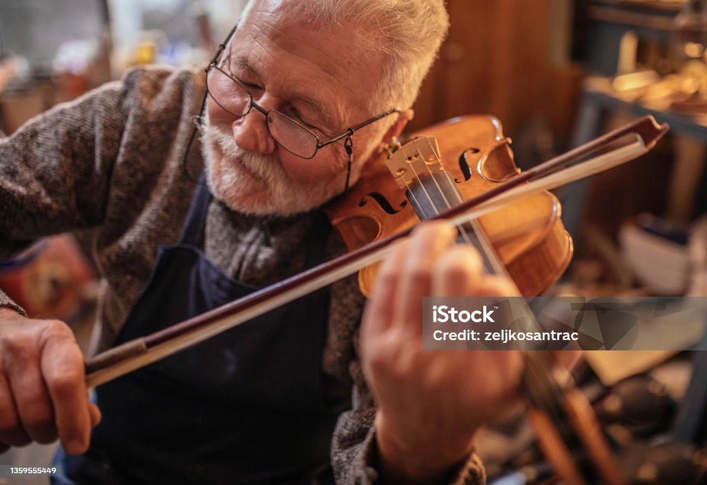 senior craftsman making  the violin Accuracy Stock Photo