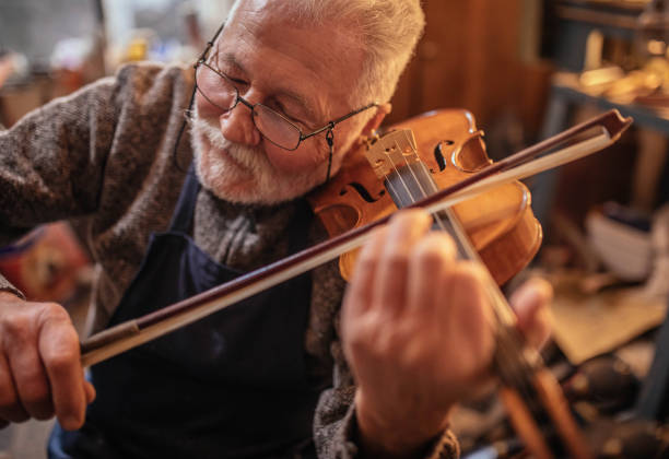 senior craftsman making  the violin stock photo
