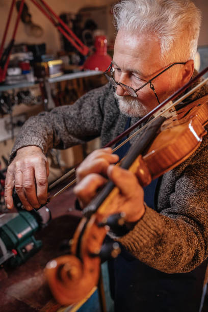 istock senior craftsman making  the violin 1359556092