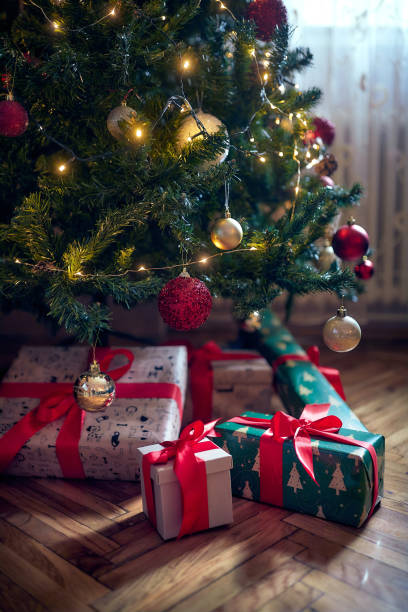 istock Hand wrapped christmas gifts under the tree 1359556530