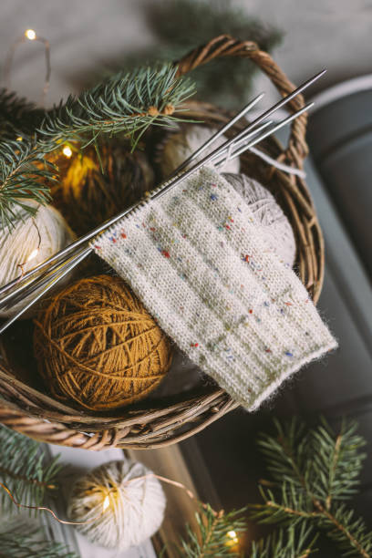 istock Hand knitting with needles and yarn balls in a basket. 1359557482