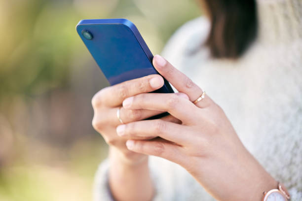 istock Cropped shot of a woman using her cellphone while standing outside 1359557697