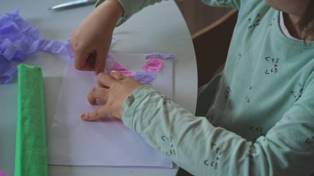 istock Smart Creative Caucasian Girl Preparing Art Project for Elementary School using Colorful Blotting Tissue Paper and Paper Glue 1359558702