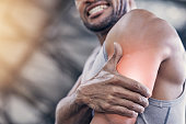 istock Closeup shot of an unrecognisable man holding his arm in pain while exercising in a gym 1359559996