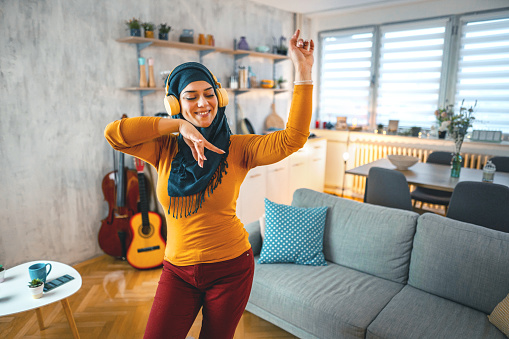 Muslim woman listening to music in her apartment