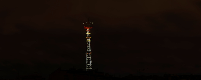 Panoramic view of illuminated TV broadcasting tower at night in Minsk. Night scenery with TV Tower in Minsk. Festive and technology concepts.