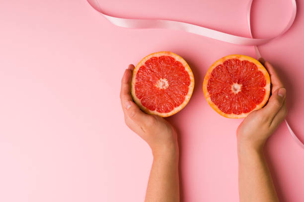 Breast cancer awareness day Young woman hands touching grapefruits and showing how to do a self-exam on the breasts to prevent cancer Self Exam stock pictures, royalty-free photos & images