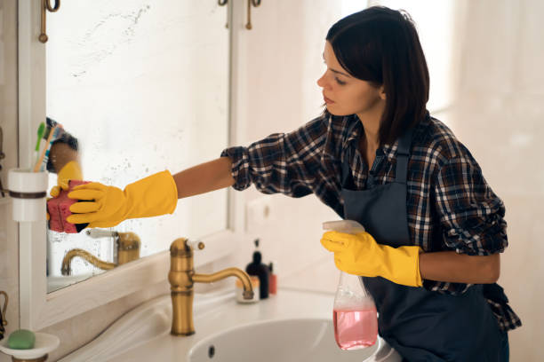 istock Young woman is washing mirror in the bathrom. 1359564872